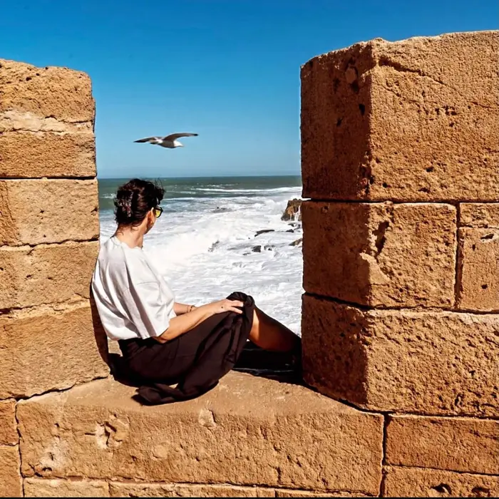 Guest sitting in the Essaouira ramparts overlooking the Atlantic Ocean