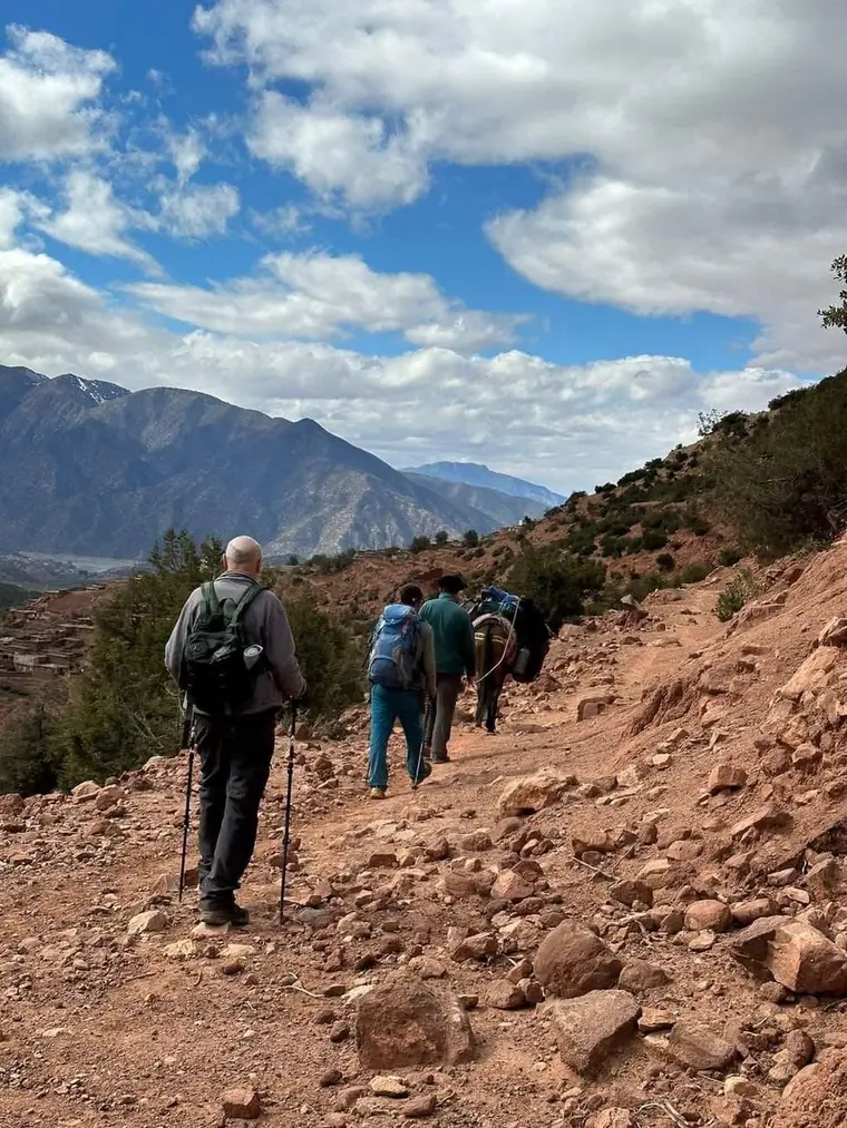 Trekking group on a mountain trail with a pack mule in the High Atlas